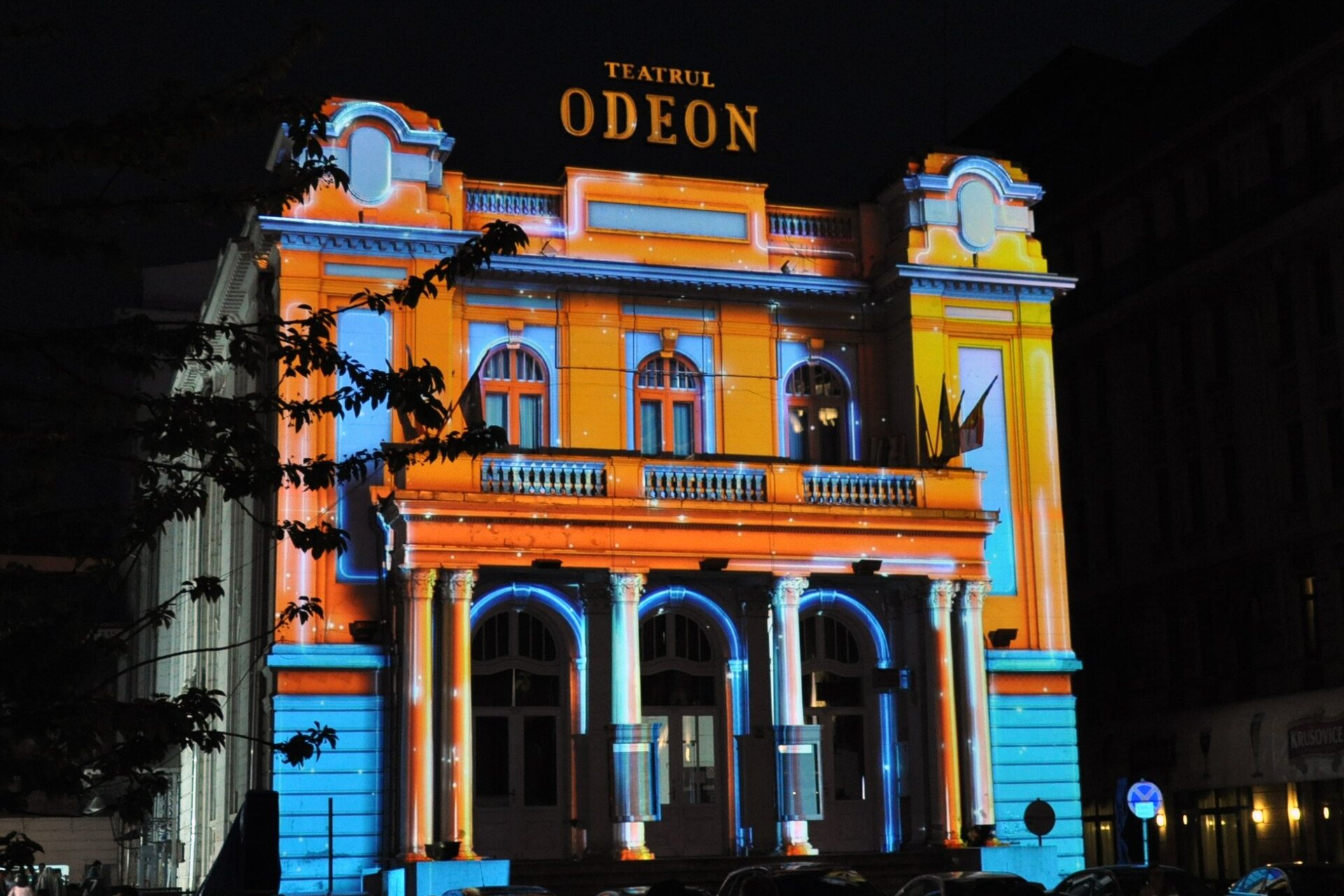 Fațada Teatrului Odeon din București, luminată în culori, seara